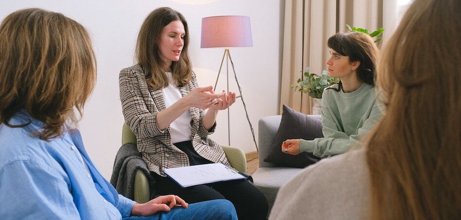 Clients and counselor in a group therapy session at a residential rehab facility in Austin.