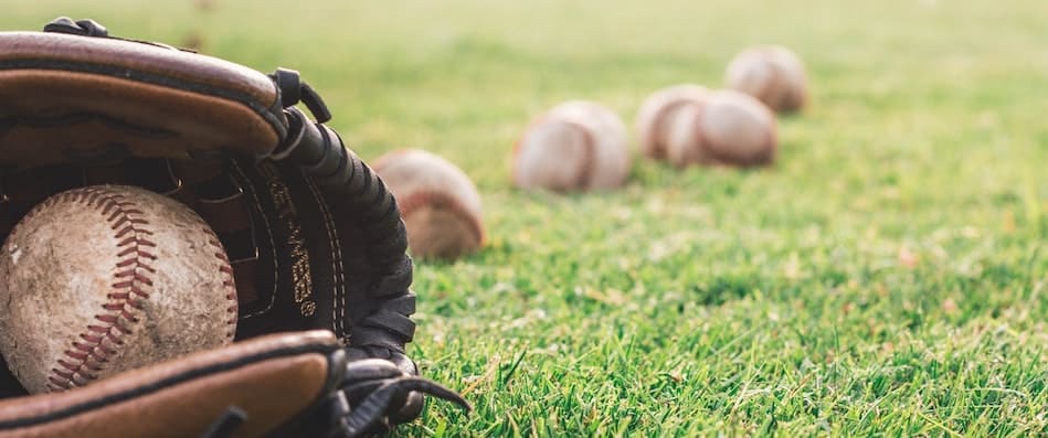 A worn baseball glove holding a ball on the grass, symbolizing Matt Bush’s off-field journey of redemption and recovery.