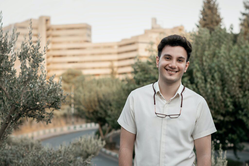 Young man smiling confidently outdoors with city buildings in the background, symbolizing hope and fresh beginnings in drug rehab Austin.