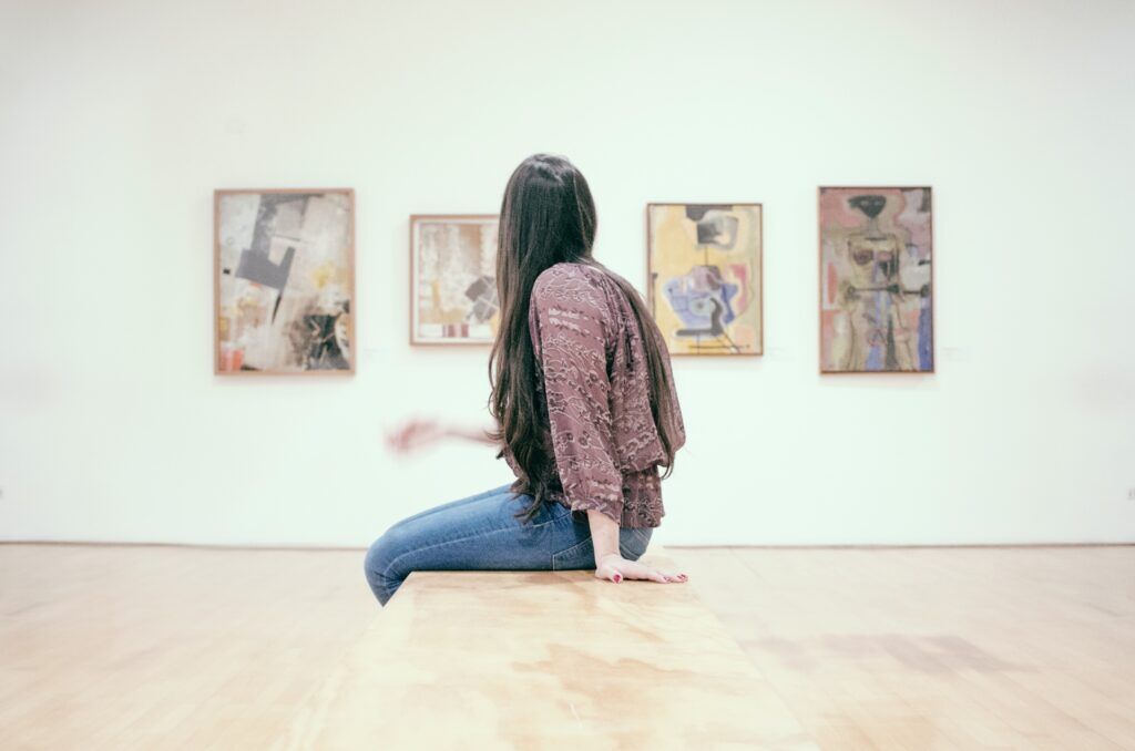 Woman reflecting in an Austin art gallery—symbolizing mindfulness, healing, and recovery through drug rehab in Austin, Texas.