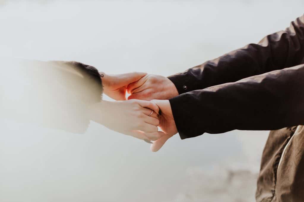 Two people holding hands, symbolizing support and connection during intensive outpatient rehab (IOP) recovery.