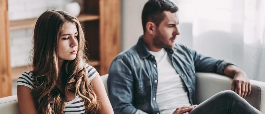 Couple showing emotional distance while coping with a loved one’s addiction