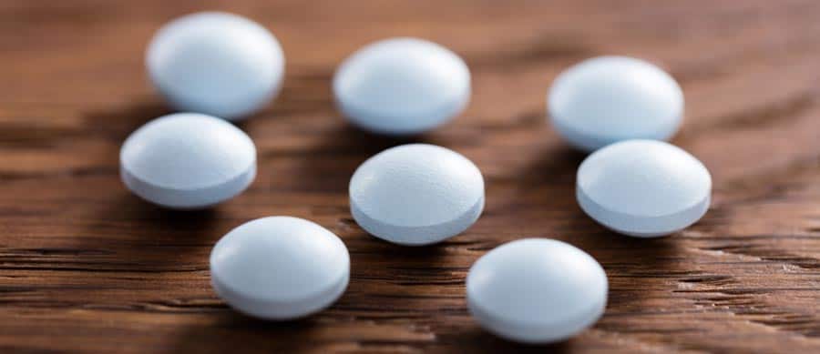 Round blue tablets representing synthetic designer drugs, highlighting risks, dangers, and the need for safe addiction treatment.